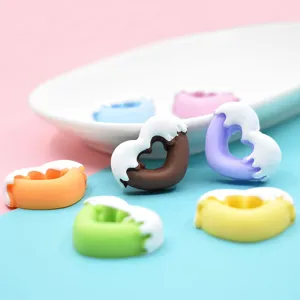 Nahaufnahme von bunten herzförmigen Donut-Harzanhängern für DIY-Handyhüllen Basteln