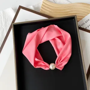 Detail view of the pink silk scarf with a pearl magnetic buckle, elegant neck accessory.