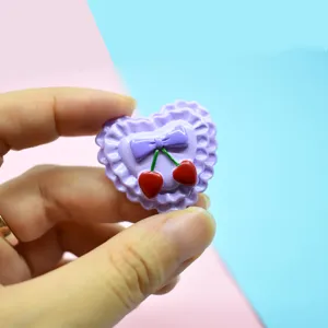 Detailed macro view of a cute macaron purple heart resin charm with cherry and bow motifs.