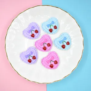 Macro detail of colorful heart-shaped cherry resin charms for DIY crafts and decorations.