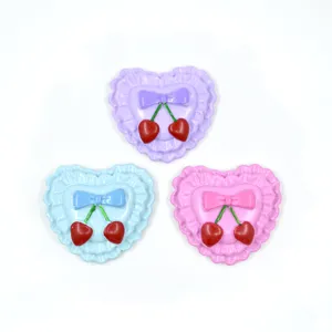 Close-up of macaron color heart resin charms with bow and cherry detail