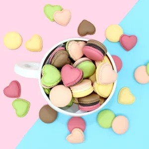 Close-up view of colorful heart and round macaron resin charms for DIY handmade crafts.