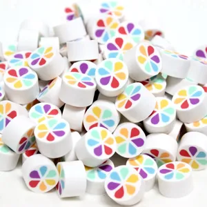 Detailaufnahme von zylindrischen Polymer-Ton-Perlen mit bunten Regenbogen-Blumenmustern für DIY.