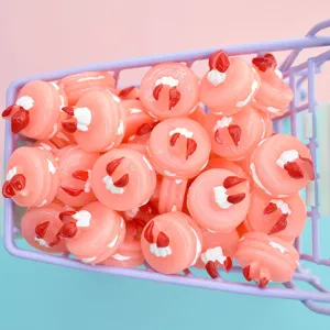 Macro view of miniature pink resin strawberry cake charms for DIY crafts and phone deco
