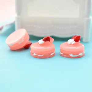 Macro detail of pink resin strawberry cake charms for DIY crafts and handmade resin art.