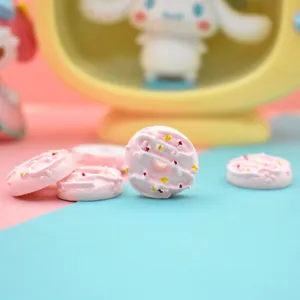 Close-up of miniature pink resin donuts with colorful sprinkles for DIY craft projects
