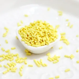 Vue macro de vermicelles cylindriques jaunes en pâte polymère pour décoration DIY.