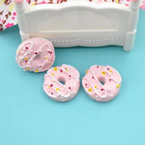 Detailed macro view of three pink resin miniature donuts for dollhouse DIY craft projects