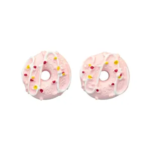Detailed macro view of two miniature pink resin donut charms for DIY jewelry crafts
