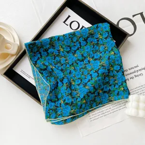 Dettaglio foulard quadrato floreale blu, morbida trama in cotone, accessorio donna.
