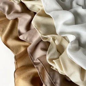Close-up detail of solid color square scarf with soft textured fabric, elegant neutral tones.