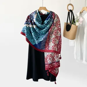 Detailed view of the ethnic paisley print scarf featuring blue red geometric patterns and fringe.