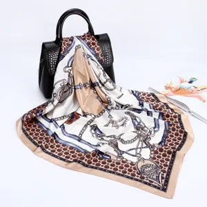 Detailed close-up view of luxury satin silk scarf featuring elegant chain and belt print design.