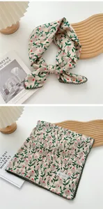 Dettaglio foulard quadrato in cotone e lino con stampa di foglie verdi e bordo in pizzo.