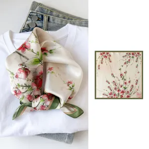 Silk floral square scarf detail showing delicate blossom print and elegant green border.