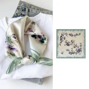 Silk square scarf detail view showcasing elegant floral print and smooth fabric texture.