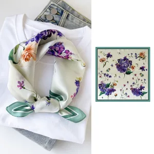 Close-up detail view of the silk square scarf featuring elegant floral print and green border.