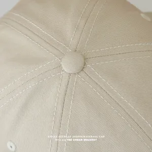 Nahaufnahme des beige Baseballcaps mit feinen Nähten und klassischer Paneelkonstruktion.