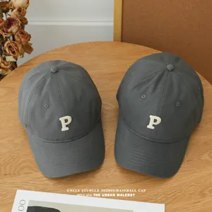 Detailansicht der dunkelgrauen Baseballkappe mit weißem P-Buchstaben, lässiger Stil.