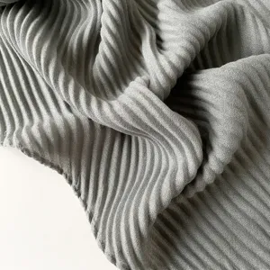 Detail shot of the fine grey pleated fabric texture, showcasing soft drape and delicate folds.