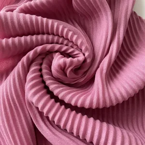 Close-up view of a vibrant pink pleated square scarf fabric showing fine texture details.