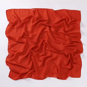 Close up detail of the solid red cotton linen square scarf showing fabric texture and natural folds.