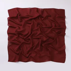 Close-up detail of dark red cotton linen square scarf fabric texture, casual draped look.