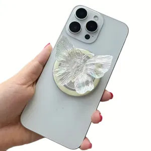 Detailed view of the iridescent laser butterfly phone grip on a white smartphone