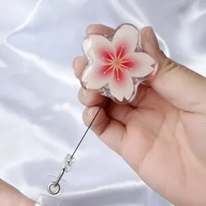 Nahaufnahme eines zarten rosa Kirschblüten-ausziehbaren Ausweishalters für Pflege.