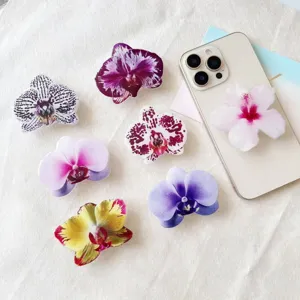 Varios soportes de acrílico para móvil con forma de orquídea en una funda de celular