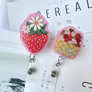 Détail du porte-badge en acrylique rose pailleté avec motif fraise et été doux