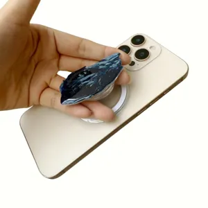 Detail of a dark blue marbled acrylic magnetic phone grip on a white smartphone