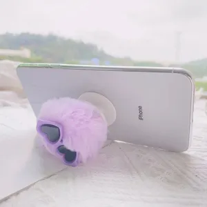 Detail van een paarse pluche hart-zonnebril telefoonhouder op een wit smartphone toestel