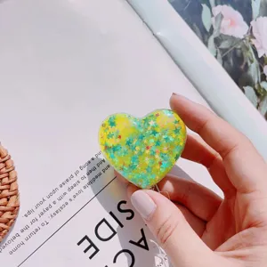 Detailed view of heart-shaped glitter retractable badge reel with stars and sequins