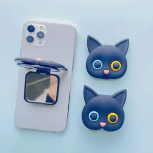 Detail showing the cat-shaped phone grip opened as a vanity mirror on a smartphone.