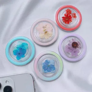 Detailed view of MagSafe phone grips with real dried flowers in resin and colorful rims