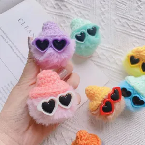 Close-up van macaron pluche bal telefoonhouders met schattige mutsen en hartvormige zonnebrillen