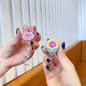 Detailed view of hand-drawn rabbit and flower retractable badge reels for nurses.