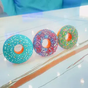 Detaillierte Ansicht von drei bunten Donut-Handyhalterungen auf einem Marmortisch
