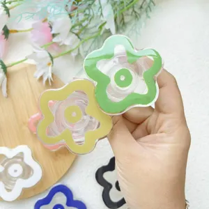 Close-up of colorful flower-shaped acrylic air cushion phone grips held by hand