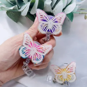 Close-up detail of butterfly retractable badge reels featuring gold foil and floral resin.