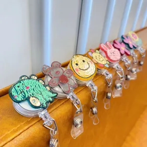 Close-up of colorful retractable badge reels with cute doodle cartoon designs on leather.