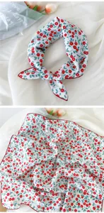 Close-up detail shot of the floral cotton linen square scarf, featuring vibrant red berries pattern.
