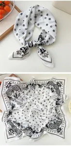 Close-up view of white cotton-linen square scarf with black grey paisley and star patterns.