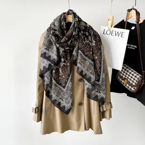 Detailed view of women's autumn paisley print cotton linen scarf draped elegantly on a trench coat.