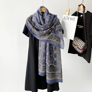 Detailed shot of a blue paisley print shawl scarf draped on black dress with elegant props.