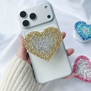 Sparkly heart diamond phone grip stand shown on a white smartphone detail view