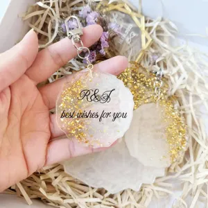 Close-up of handmade epoxy resin keychain with gold foil and best wishes for you text