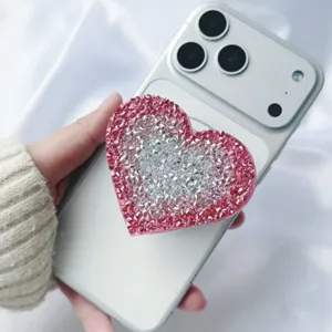Heart-shaped rhinestone phone grip with pink and silver crystals on a silver phone