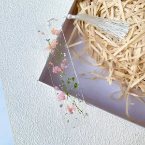Handmade resin bookmark with pressed real pink flowers and white tassel detail.